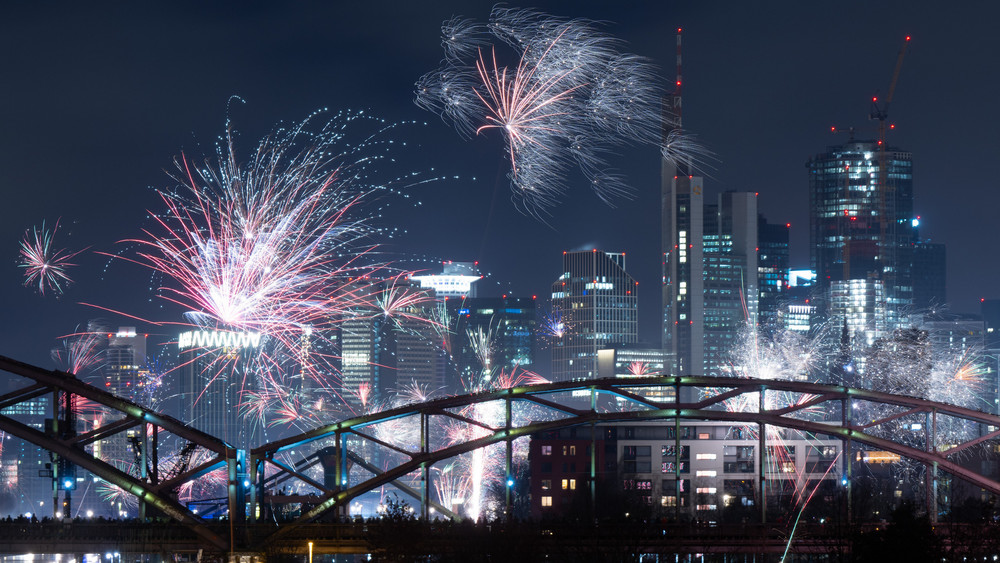 Mit Feuerwerk feiern Menschen vor der Bankenskyline in Frankfurt das neue Jahr 2024. Die Polizei und Rettungsdienste waren mit einem Großaufgebot in der Innenstadt präsent.