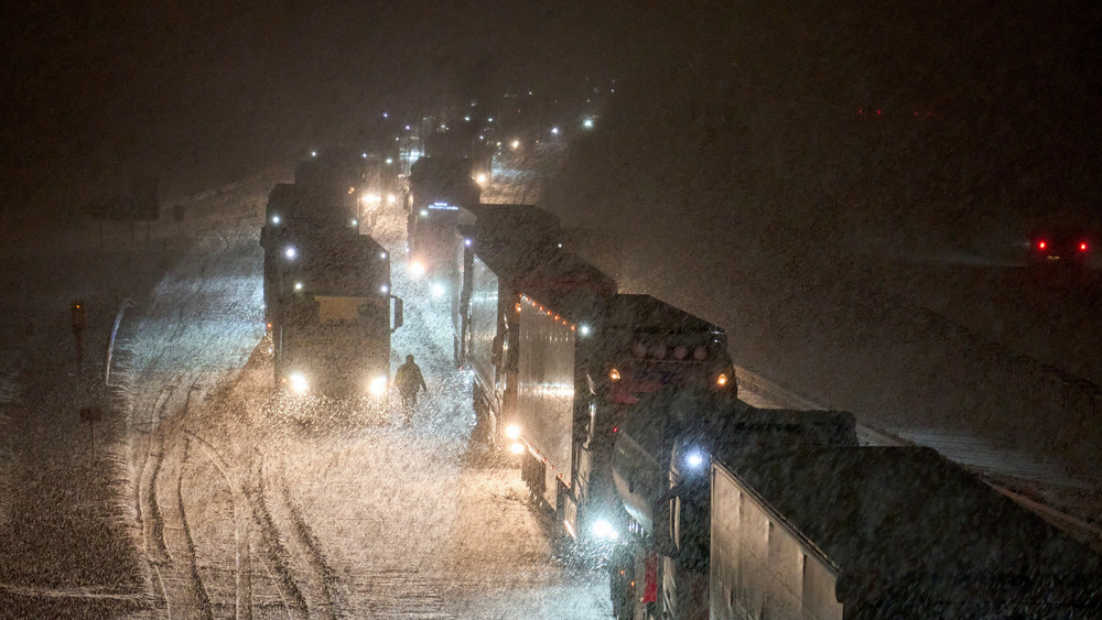 LKW stauen sich nach einem Verkehrsunfall auf der schneebedeckten Autobahn A3 zwischen Ransbach-Baumbach und Dierdorf.