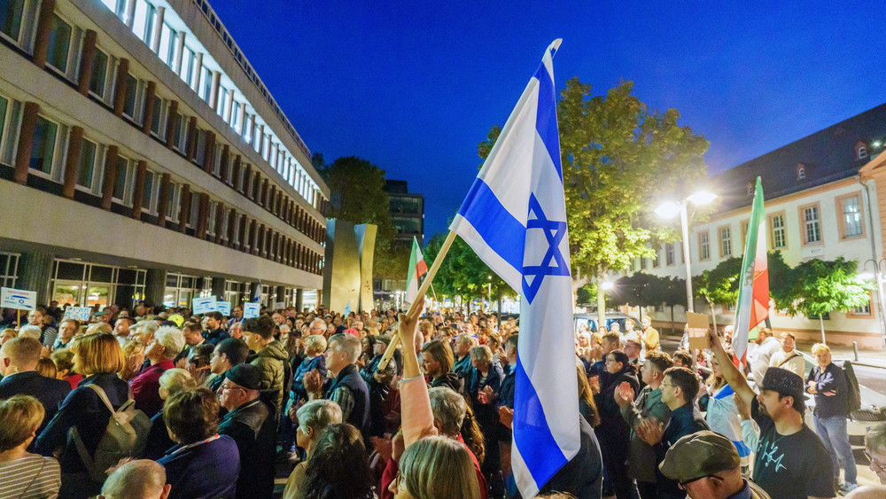Eine Teilnehmerin hält auf der Solidaritätskundgebung eine Flagge des Staates Israel hoch. Die jüdische Kultusgemeinde Mainz-Rheinhessen und die deutsch-israelische Gesellschaft Mainz haben unter dem Motto "Nein zu Terror, ja zu Israel" zu einer Solidaritätskundgebung in der Innenstadt aufgerufen.