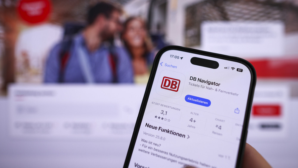 Eine Hand hält ein Mobiltelefon mit der App DB-Navigator im App-Store. Ab dem 19. Mai 2025 wird das Landgericht Frankfurt über die Rechtmäßigkeit der Datenverarbeitung in der Bahn-App DB Navigator entscheiden.