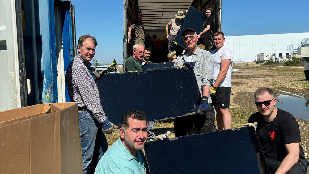 Ehrenamtliche Helfer verladen rund 15.000 Solar-Panels in LKWs, die Richtung Ukraine starten.