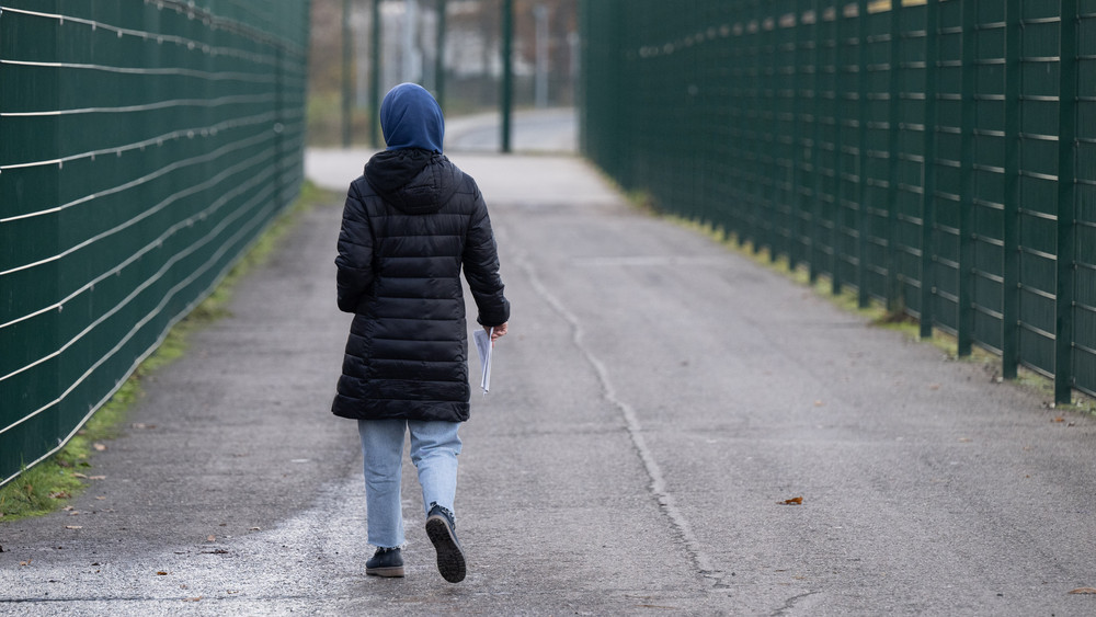 Eine Frau läuft in der Erstaufnahmeeinrichtung in Gießen zu ihrer Unterkunft.