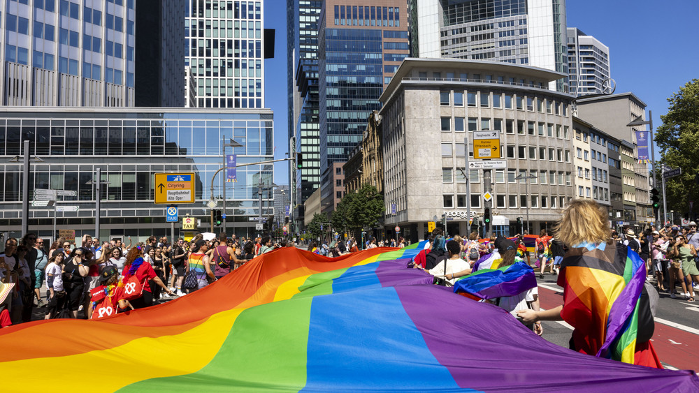 Tausende Menschen feiern mit einer großen Regenbogenfahne beim Christopher Street Day (CSD) Frankfurt unter dem Motto "Wir sind extrem Liebevoll" in der Innenstadt.