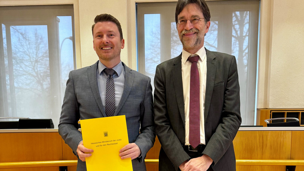 Dominik Dute (li.) mit der Ernennungsurkunde, überreicht vom Präsidenten des Landgerichts Fulda, Dr. Jochen Müller (re.).