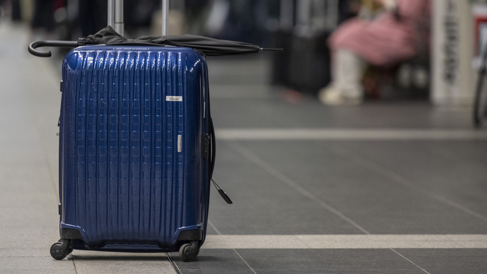 Ein blauer Koffer steht einsam herum.