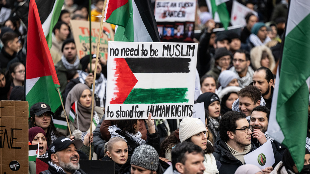 „No need to be Muslim to stand for human Rights“ steht auf dem Plakat auf einer pro-palästinensischen Demo in der Innenstadt von Frankfurt. Die Kundgebung wurde von einem massiven Polizeiaufgebot begleitet.