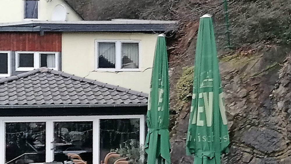 Ein großer Riss zieht sich durch die Wand in dem Haus nach dem Felssturz. 