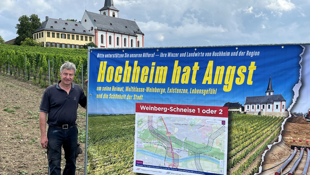 Winzer Gunter Künstler vor einem der großen Protestplakate in den Hochheimer Weinbergen.