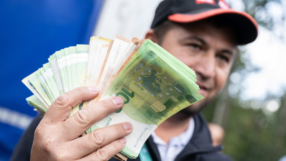 Ein Bündel mit Euro-Banknoten schwenkt ein LKW-Fahrer auf der Raststätte Gräfenhausen.