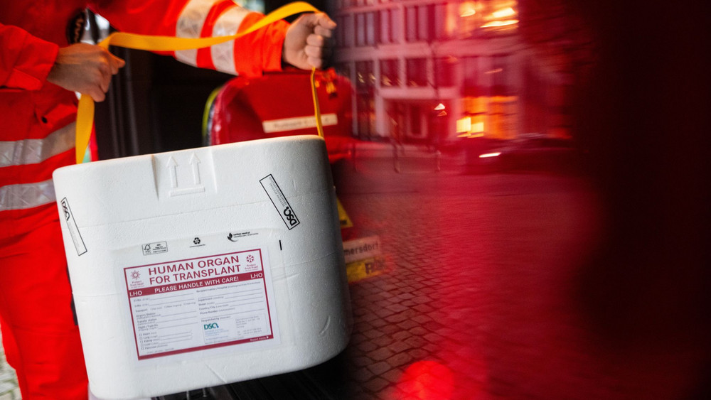 Mitarbeiter des DRK stellt Kühlbox für eine Organspende ins Auto