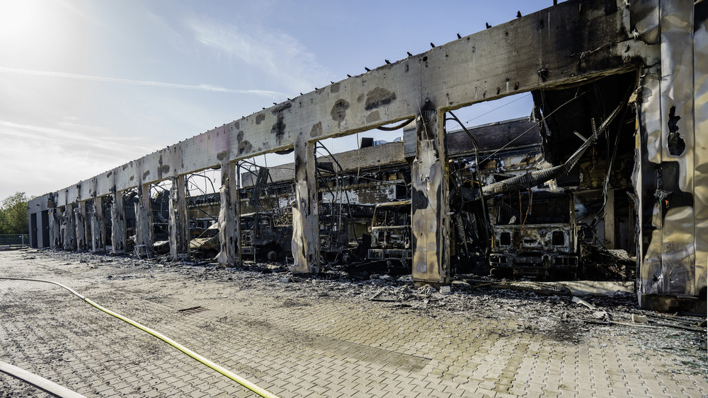 In der Fahrzeughalle stehen ausgebrannte Einsatzfahrzeuge.