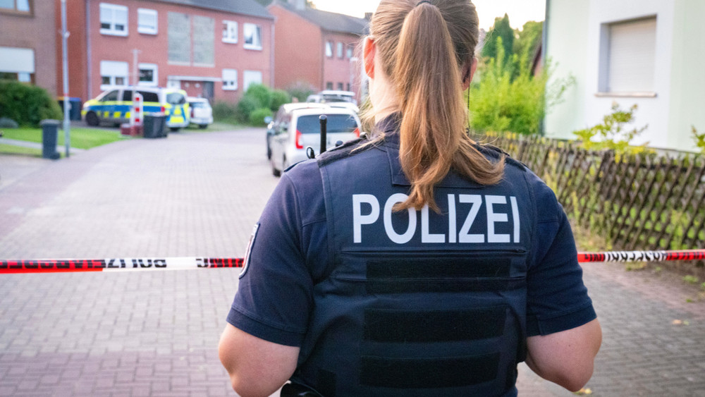 Eine Polizistin steht am Tatort vor einem Absperrband. Ein 26-Jähriger Mann ist nach einem mutmaßlichen Angriff auf mehrere Passanten durch Polizeischüsse tödlich verletzt worden.