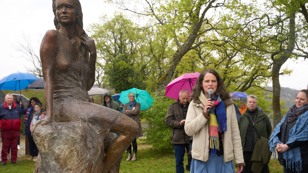 Die Berliner Künstlerin Valerie Otte erläutert die von ihr geschaffene Loreley-Statue auf dem Loreley-Plateau hoch über dem Rhein. 