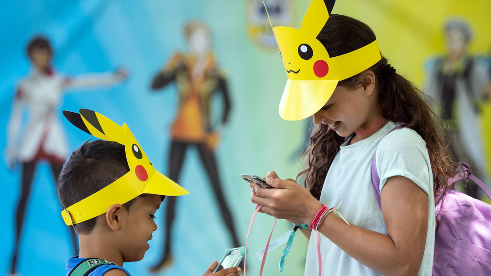 Der achtjährige Leo (l) und seine zehnjährige Schwester Lea (r) aus Basel spielen Pokémon auf ihrem Handy. 