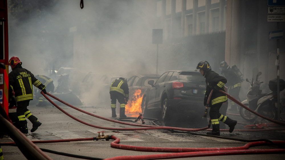 Feuerwehrleute löschen Autos nach einer Explosion in der Innenstadt von Mailand. Laut Medienberichten geriet nach ersten Erkenntnissen ein Kleinlaster in Brand, der Sauerstoffflaschen transportierte. Mindestens eine davon explodierte, in der Folge fingen etliche Autos Feuer.