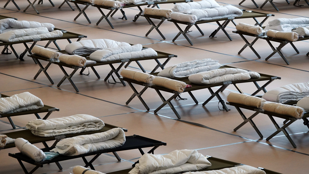 Notbetten mit Kissen und Decken in einer Unterkunft. Auch in der Turnhalle der Comenius-Schule in Herborn werden jetzt Notbetten aufgestellt - aber nur vorübergehend.
