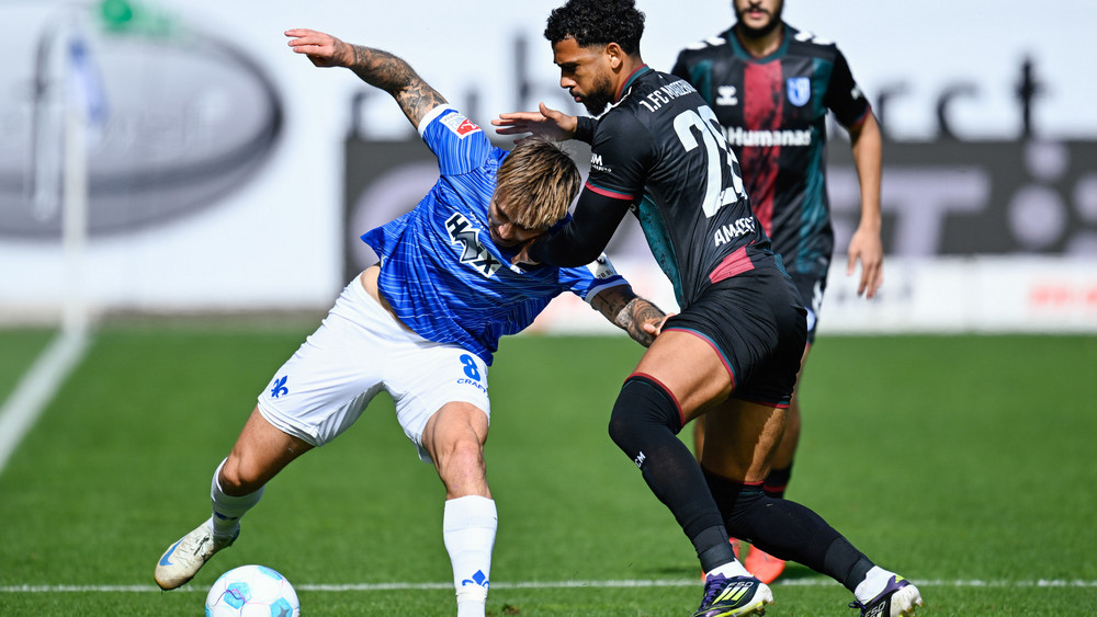 Darmstadts Luca Marseiler (li.) und Magdeburgs Xavier Ameachi kämpfen um den Ball.