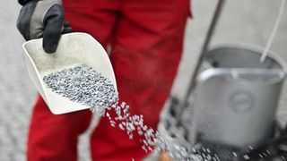 Jugendliche legen Säcke mit Streugut auf Gleise