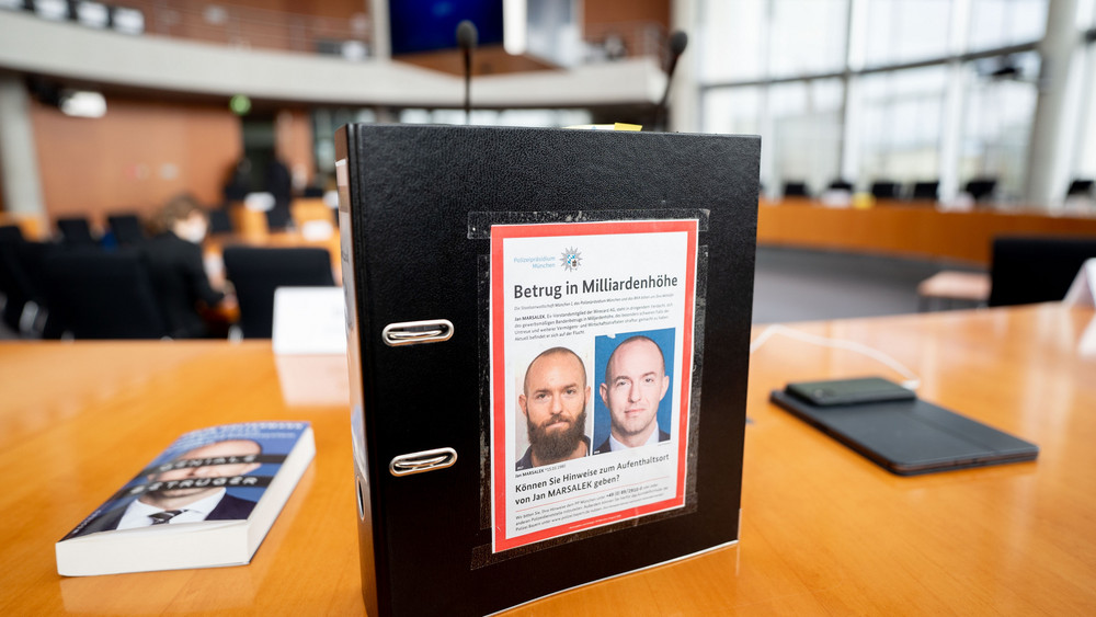 Der Aktenordner des Bundestagsabgeordneten de Masi (Die Linke) ist mit Fahndungsfotos des früheren Wirecard-Finanzvorstands Jan Marsalek beklebt.