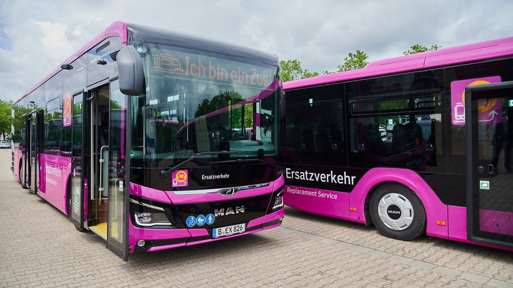 Alle Busse sind rundherum purpurfarben und mit „Ersatzverkehr Replacement Service“ beschriftet.