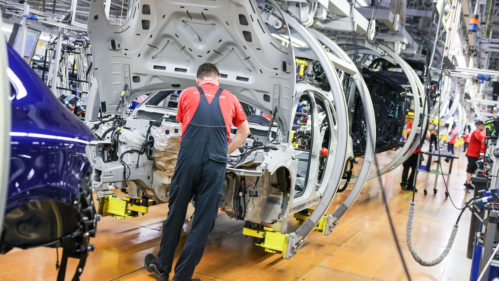 Ein Mitarbeiter arbeitet in einer Autofabrik an einer Karosserie. (Symbolbild)