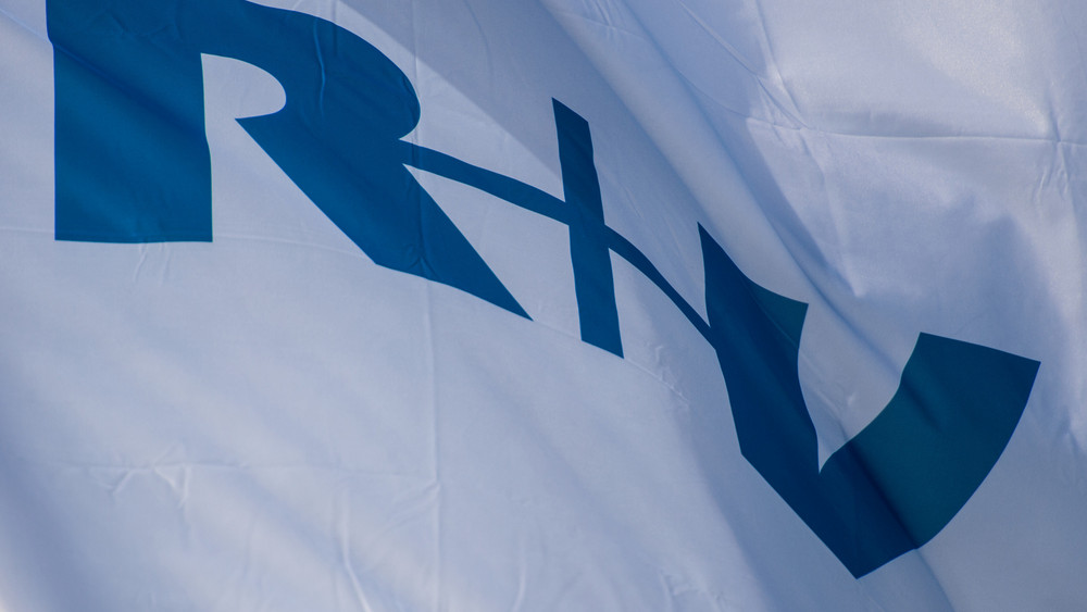 Eine Fahne mit dem Logo "R+V" flattert vor der Firmenzentrale des Versicherungs-Unternehmens in Wiesbaden im Wind.