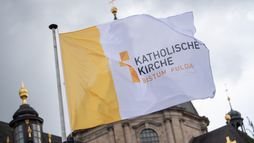 Eine Fahne mit der Aufschrift "Katholische Kirche Bistum Fulda" weht vor dem Dom St. Salvator zu Fulda (Archivbild).