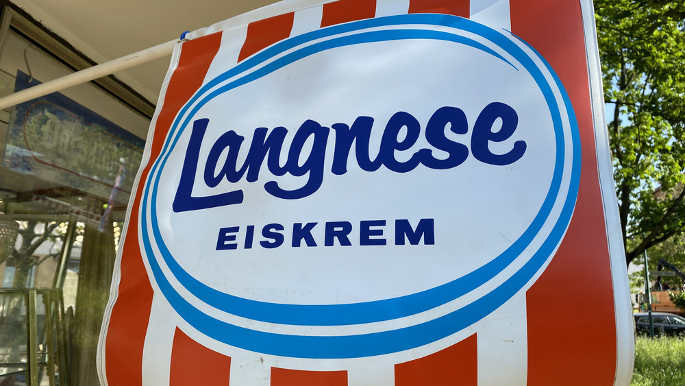 Die rot-weiße Flagge am Kiosk wirbt in alter Schreibweise für "Eiskrem" von Langnese.