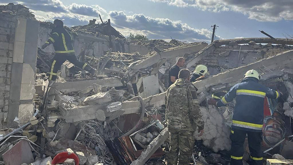 Rettungskräfte suchen in den Trümmern  eines Hauses nach Überlebenden.