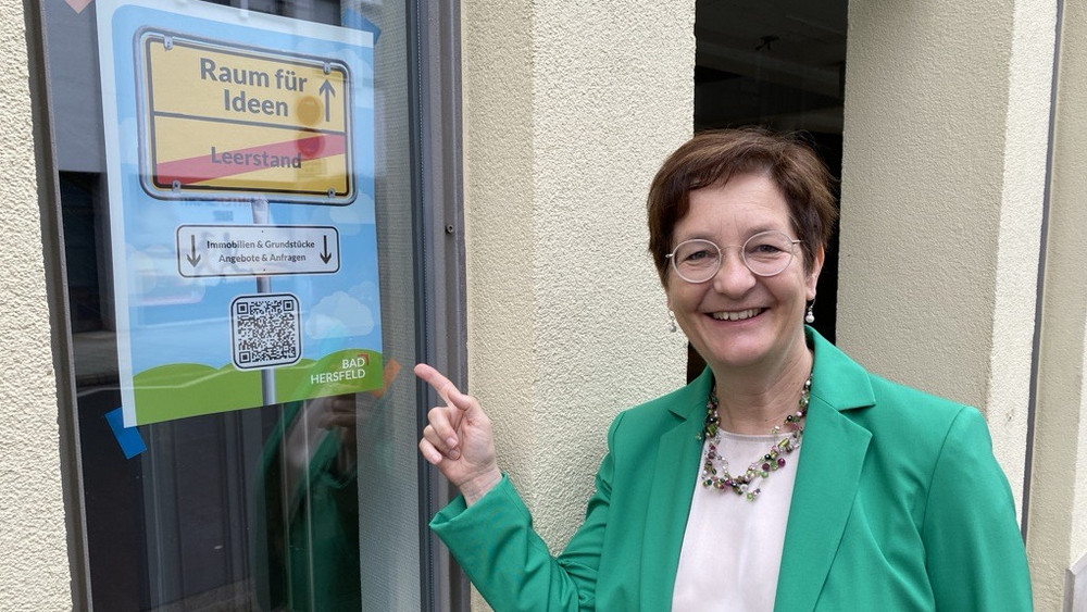 Bürgermeisterin Anke Hofmann neben einem der leerstehenden Geschäftsräume in der Innenstadt, für die sich auf dem Portal ein Exposé findet. Ein eigens dafür kreiertes Plakat weist auf die Immobilien teilnehmender Vermieter hin.