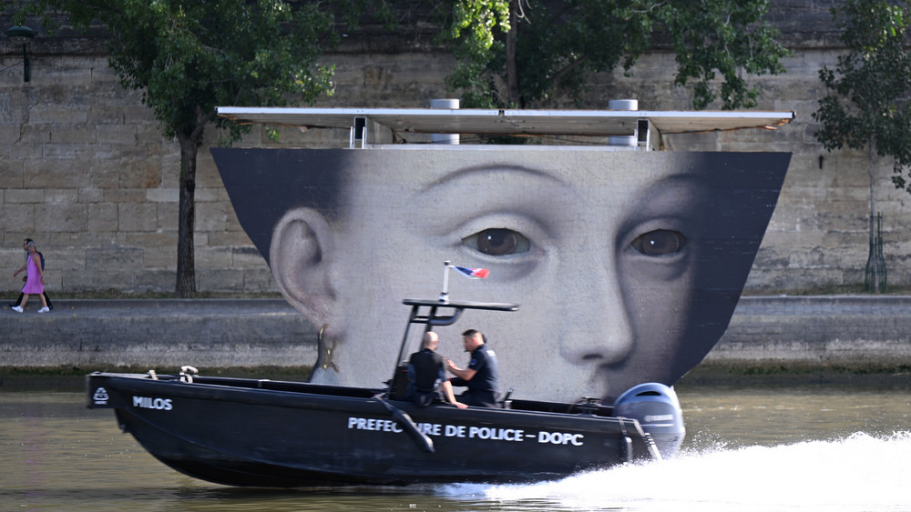 Polizisten fahren auf einem Boot die Seine entlang. 