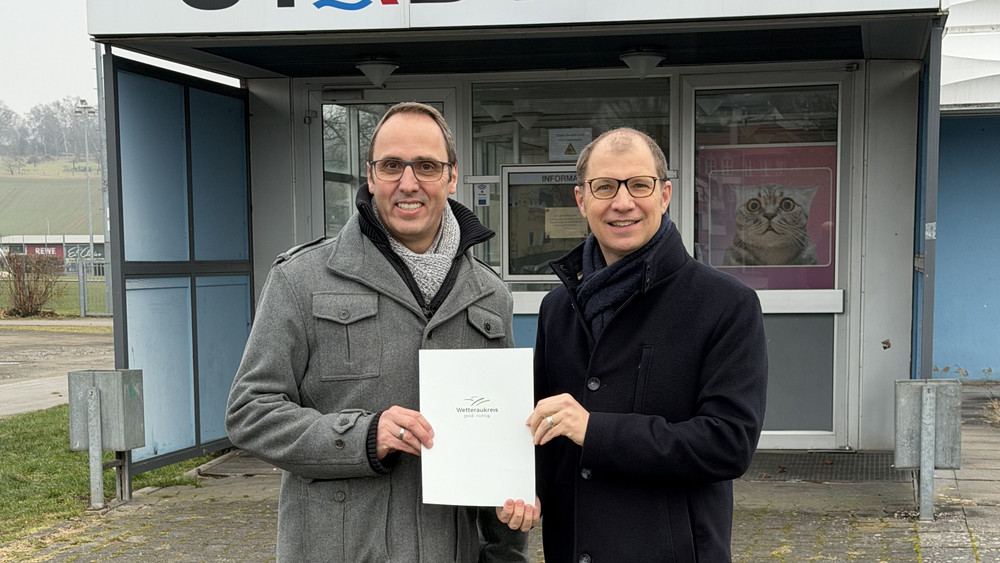 Landrat Jan Weckler (rechts) übergab die Baugenehmigung für das neue Hallenbad an Bürgermeister Thorsten Eberhard.  