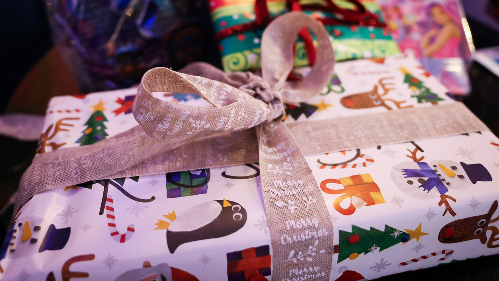 Weihnachtlich verpackte Geschenke liegen auf einem Tisch.
