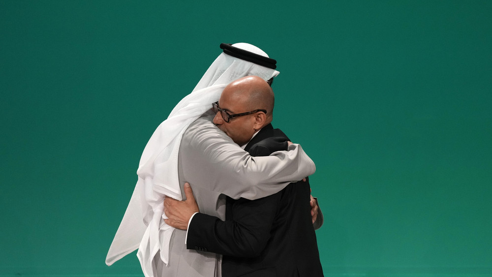 Konferenzpräsident Sultan al-Dschaber und UN-Klimachef Simon Stiell (r) umarmen sich auf dem UN-Klimagipfel in Dubai.