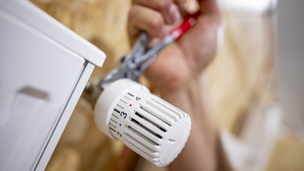 Ein Handwerker arbeitet an einem Heizkörper