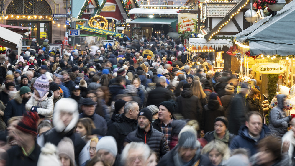 Viele Besucher strömen zwischen den Verkaufs- und Imbissständen auf dem Weihnachtsmarkt in Frankfurt hindurch. 