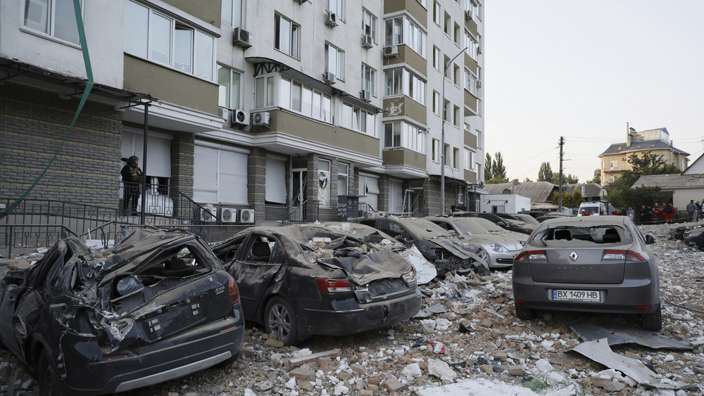 Beschädigte Autos stehen im Hof eines mehrstöckigen Wohnhauses, das bei dem dritten russischen Luftangriff auf die ukrainische Hauptstadt innerhalb der letzten 24 Stunden beschädigt wurde.