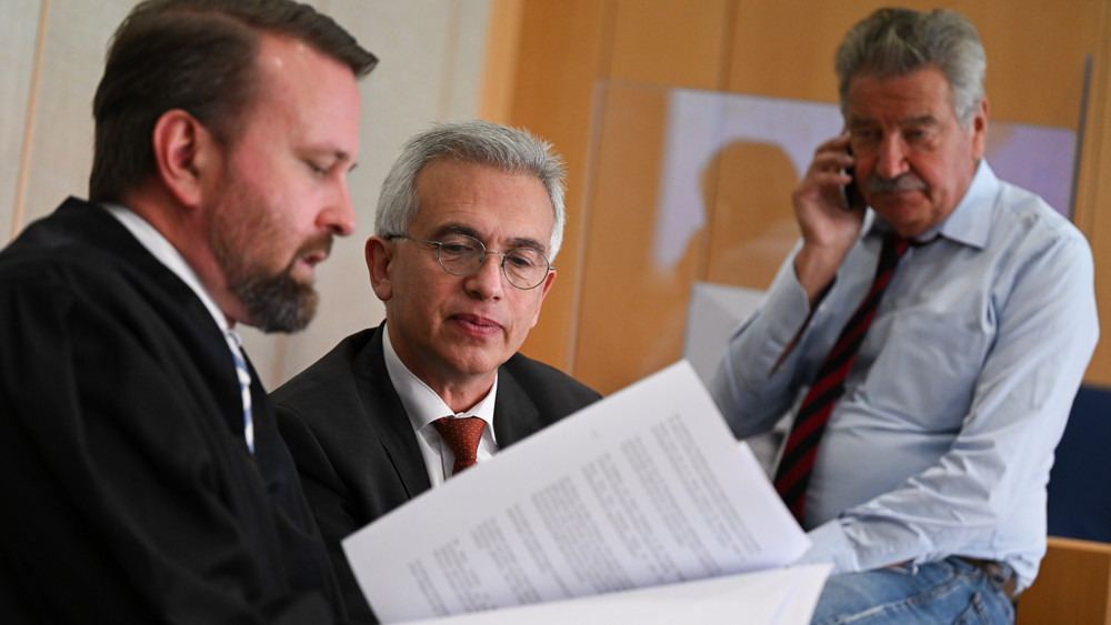 Peter Feldmann (SPD, M), Oberbürgermeister von Frankfurt am Main, unterhält sich während einer Pause des zweiten Prozesstages im Gerichtssaal des Landgerichts mit seinen beiden Anwälten.