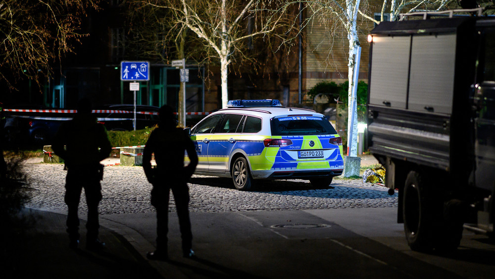 Einsatzkräfte der Polizei stehen am abgesperrten Tatort. Ein vermutlich psychisch kranker Mann ist am Abend bei einem Polizeieinsatz durch einen Schuss aus der Dienstwaffe eines Beamten tödlich verletzt worden.