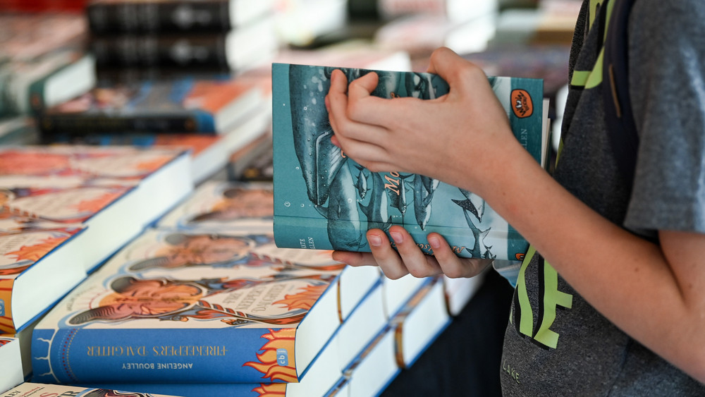 Ein Kind hält ein Buch in der Hand.