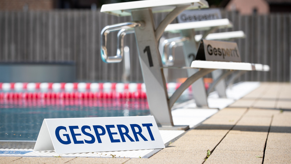 "Gesperrt" ist auf einem Schild zu lesen, das vor dem Startblock in einem geschlossenen Freibad steht (Symbolbild)