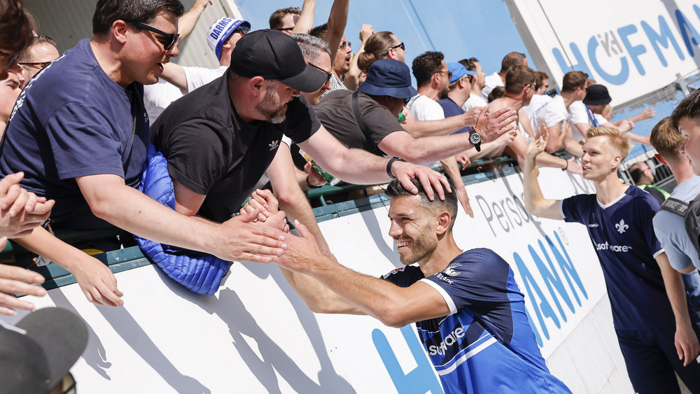 Der Darmstädter Klaus Gjasula (l) klatscht die Fans ab.