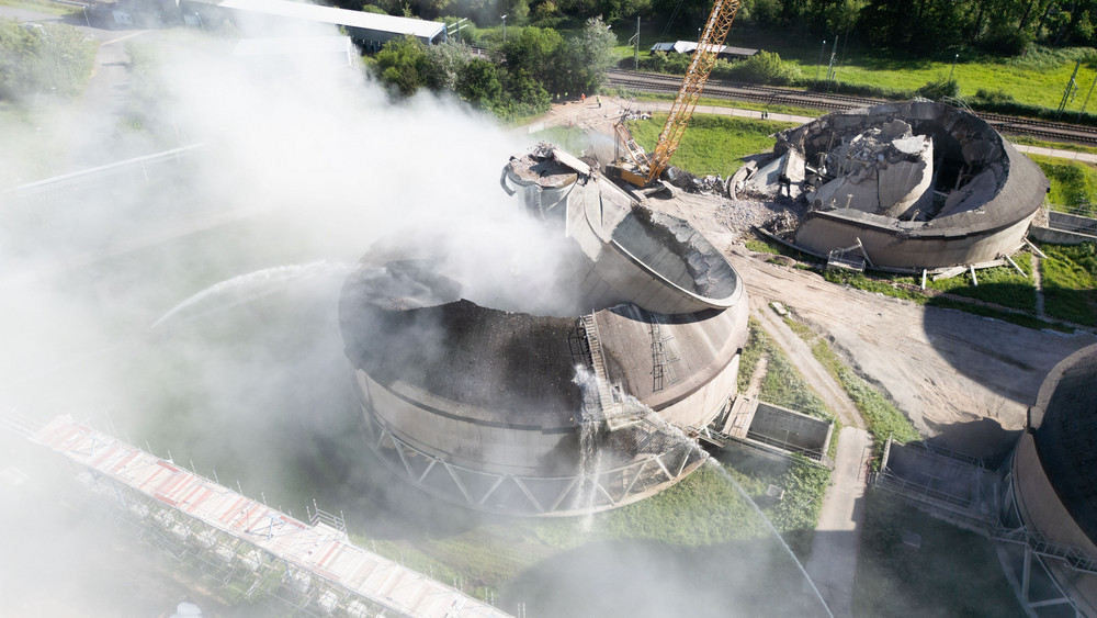 Der Kühlturm auf dem Gelände des Kohlekraftwerks Staudinger in Großkrotzenburg sackt in einer Staubwolke in sich zusammen.