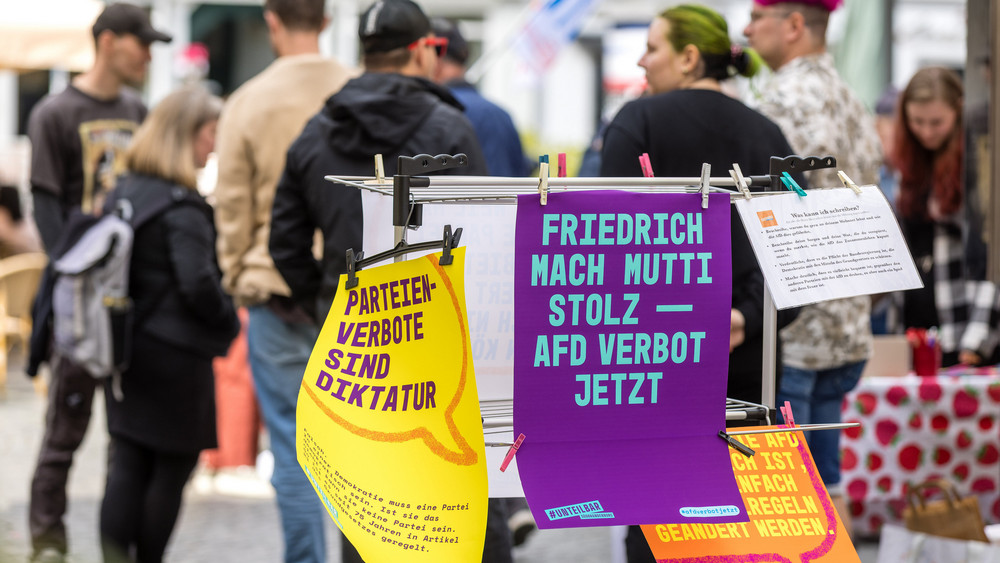 An Wäscheständern hängen bei einer Kundgebung Plakate, auf denen ein AfD Verbot gefordert wird oder die sich mit Gegenargumenten auseinandersetzen. Unter dem Motto «Keine Ausreden mehr - AfD-Verbot jetzt» haben Initiativen zu Kundgebungen in ganz Deutschland - wie hier in Cottbus - aufgerufen.