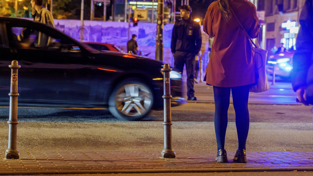 Eine Frau steht an einer Fußgängerampel. Beim Überqueren der Ampel fährt jemand in einem Auto über ihren Fuß - der Fahrer flüchtet (Symbolfoto).