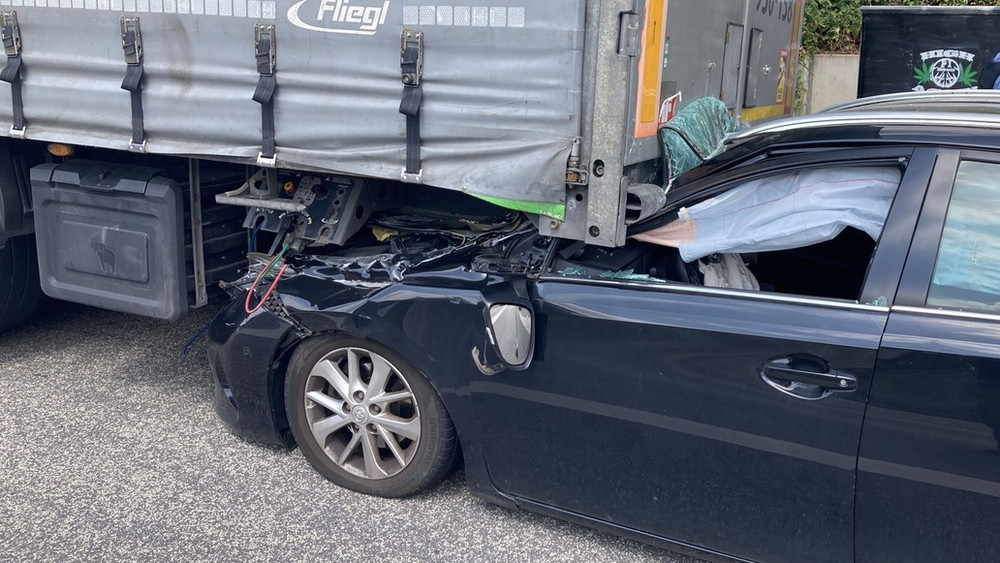 Das Auto ist unter dem Anhänger verkeilt. 