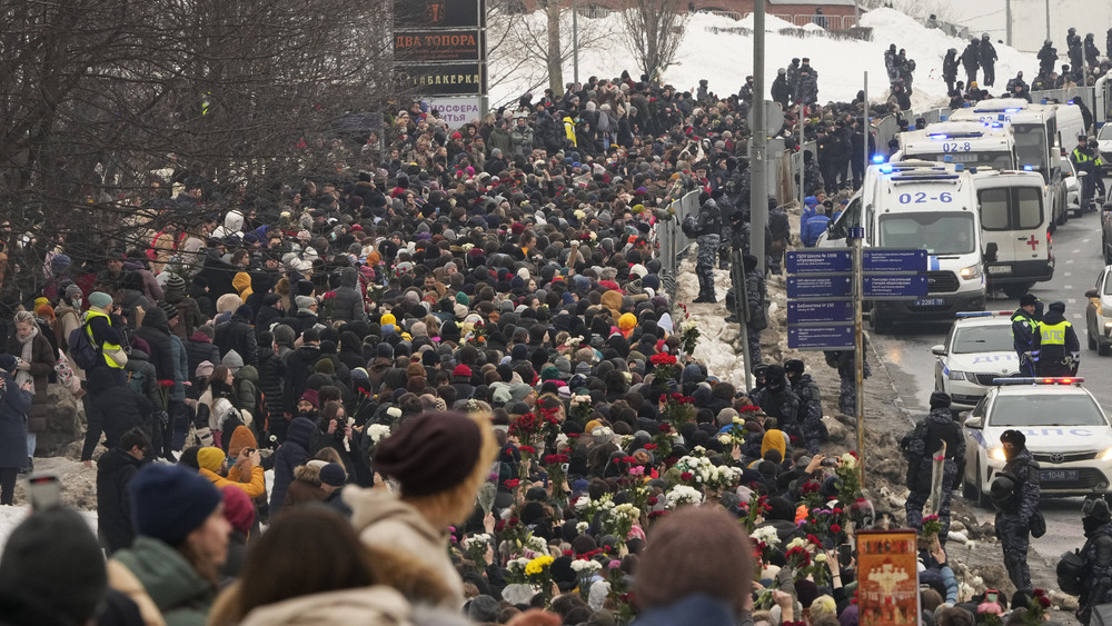 Polizisten (r) beobachten, wie Menschen zur Beerdigungszeremonie des russischen Oppositionellen Nawalny zum Friedhof Borisowskoje gehen.