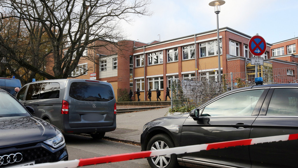 Einsatzkräfte stehen bei einer Bedrohungslage in Hamburg vor einer Schule, wo zwei Jugendliche oder Kinder am Mittwochmittag mit einer Schusswaffe in der Schule gewesen sein sollen und laut Polizei möglicherweise eine Lehrerin bedroht haben.