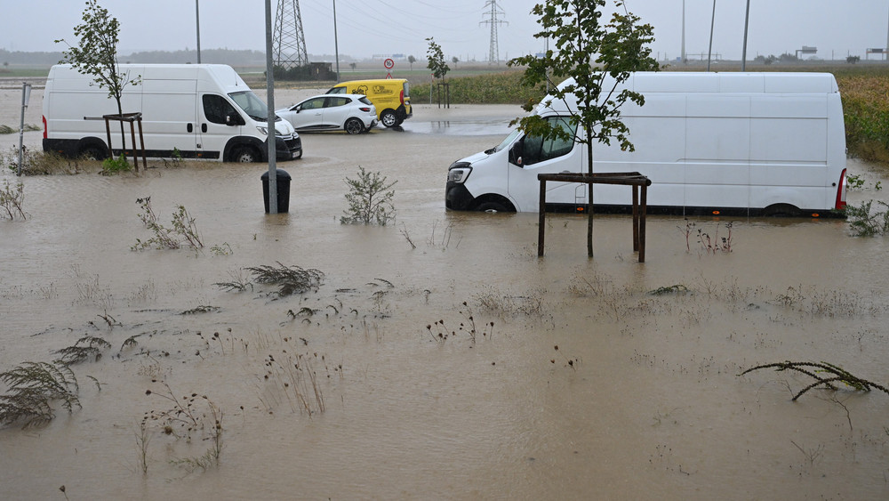 Pkw und Lieferwagen stehen auf einem überfluteten Parkplatz in Niederösterreich im Wasser.