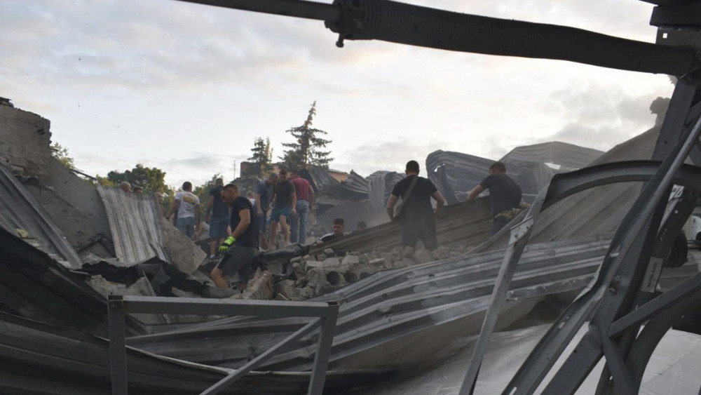 Menschen beseitigen Trümmer nach dem russischen Angriff in Kramatorsk.